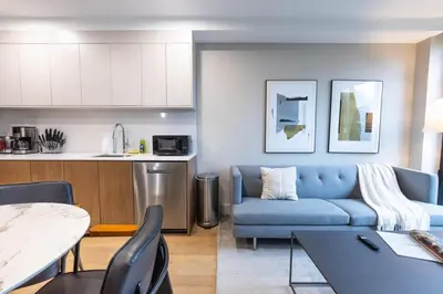 a living room with a blue couch and a kitchen at 149BK-301 New Construction 1BR Prime BK WD in Brooklyn