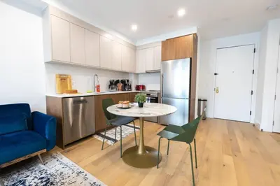 a kitchen with a table and a blue couch at 149BK-302 New Construction 1BR WD in unit Balcony in Brooklyn