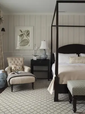 a bedroom with a bed and a chair and a table at The White Hart in Salisbury