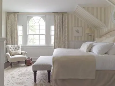 a white bedroom with a large bed and a chair at The White Hart in Salisbury
