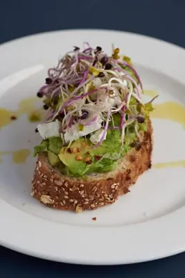a plate with a piece of bread with a salad on it at The White Hart in Salisbury