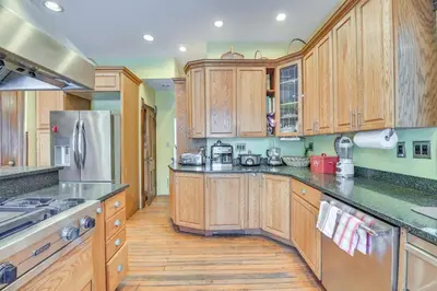 a kitchen with wooden cabinets and a stainless steel refrigerator at 5 Mi to Belleayre Lake Getaway in Fleischmanns! in Fleischmanns