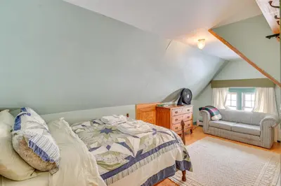 a bedroom with a bed and a chair and a window at 5 Mi to Belleayre Lake Getaway in Fleischmanns! in Fleischmanns