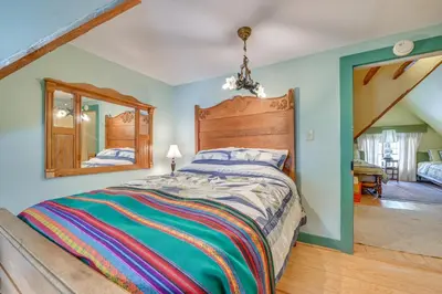 a bedroom with a large bed and a mirror at 5 Mi to Belleayre Lake Getaway in Fleischmanns! in Fleischmanns