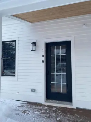 a white house with a black door on it at Luxury TownHome 106 in Wilmington