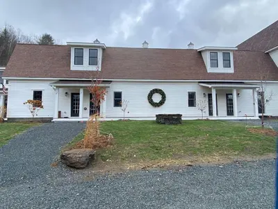 a white house with areath on the front of it at Luxury TownHome 106 in Wilmington