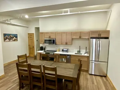 a kitchen with a wooden table and a refrigerator at Luxury TownHome 106 in Wilmington