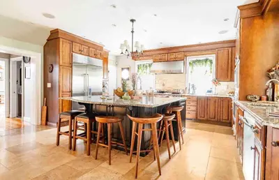 a large kitchen with a large island with bar stools at The Historic Jesse Buel Farmhouse w Heated Pool in Albany