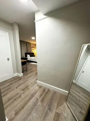 an empty living room with a mirror on the wall at Yale Casa Rosa Studio in New Haven