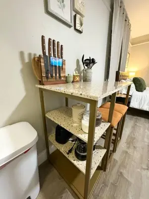 a kitchen with a shelf with utensils on it at Yale Casa Rosa Studio in New Haven