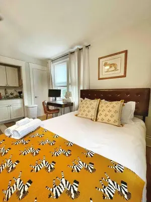 a bedroom with a large bed with an orange blanket at Chateau Blanc Yale Located Downtown in New Haven