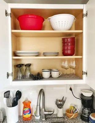 a kitchen shelf with dishes and bowls and a sink at Chateau Blanc Yale Located Downtown in New Haven