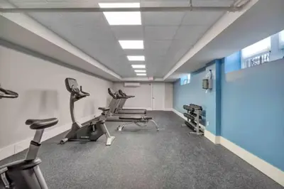a gym with treadmills and chairs in a room at Chateau Blanc Yale Located Downtown in New Haven