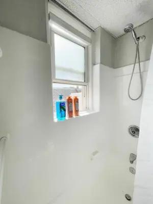 a bathroom with a shower and a window at Chateau Blanc Yale Located Downtown in New Haven