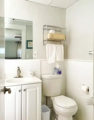 a white bathroom with a toilet and a sink at Chateau Blanc Yale Located Downtown in New Haven