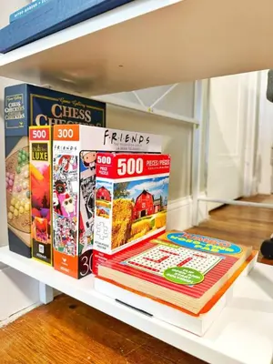 a shelf with a stack of magazines and books at Yale Casa Verde Studio in New Haven