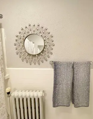 a bathroom with a mirror and towels and a radiator at Yale Casa Azul Studio in New Haven