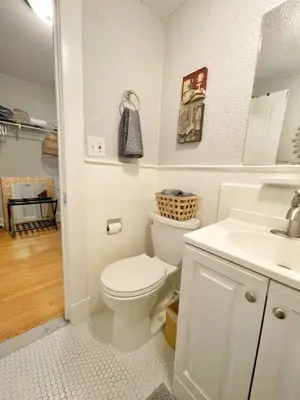 a white bathroom with a toilet and a sink at Yale Casa Azul Studio in New Haven