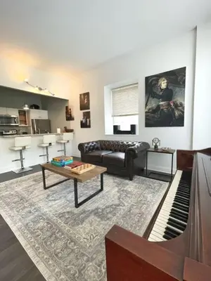 a living room with a couch and a piano at Yale Modern Downtown Chateau in New Haven