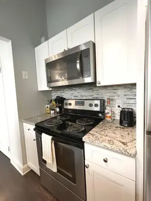 a kitchen with a stove and a microwave at Yale Modern Downtown Chateau in New Haven