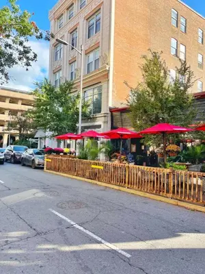 a restaurant with red umbrellas in front of a building at Yale Modern Downtown Chateau in New Haven