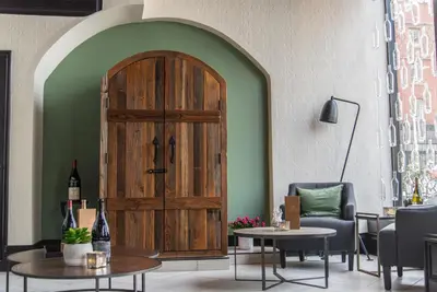 a large wooden door in a room with chairs and tables at Windrose on Hudson in Ossining
