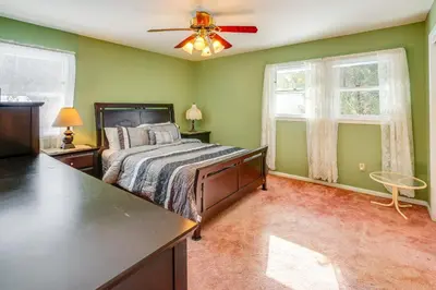 a bedroom with a bed and a ceiling fan at 9 Mi to Lake George Village Home in Queensbury in Queensbury