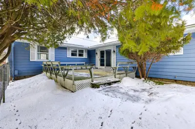 a blue house with a bench in the snow at 9 Mi to Lake George Village Home in Queensbury in Queensbury
