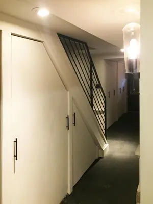 a hallway with a staircase and a white door at JC Moroccan Hideaway in Jersey City