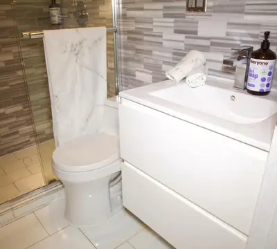 a white bathroom with a toilet and a sink at New2 York Style Stay near Central Park in New York