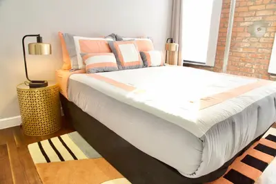 a large bed in a room with a brick wall at New2 York Style Stay near Central Park in New York