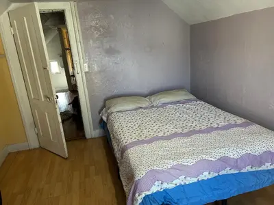 a small bedroom with a bed and an open door at 1Br Studio At East Rock in New Haven