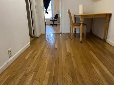 a room with a wooden floor and a table and a desk at 1Br Studio At East Rock in New Haven