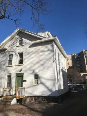 a white house with a green door on a street at 1Br Studio Across From Yale New Haven Hospital in New Haven