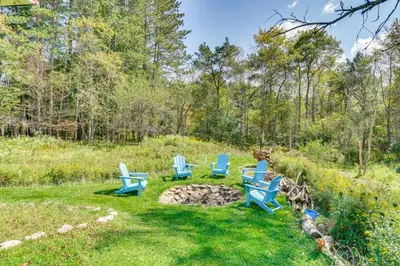 a group of blue chairs sitting in the grass at Peaceful 1-Acre Parksville Home Large Deck and Yard in Parksville