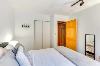 a bedroom with a white bed and a wooden door at Peaceful 1-Acre Parksville Home Large Deck and Yard in Parksville