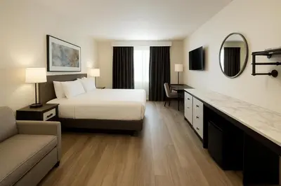 a hotel room with a bed and a desk at Nova Hotel JFK in Hillside