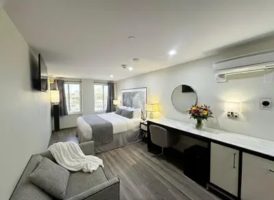a hotel room with a bed and a desk at Nova Hotel JFK in Hillside