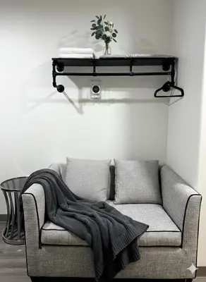 a living room with a couch with a blanket on it at Nova Hotel JFK in Hillside