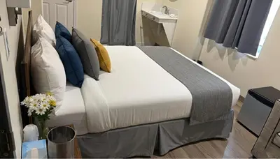 a bedroom with a bed with blue and white pillows at Nova Hotel JFK in Hillside