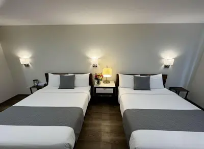 two beds in a hotel room with two lamps at Nova Hotel JFK in Hillside