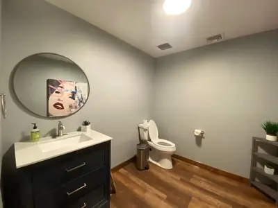 a bathroom with a sink and a mirror and a toilet at STUNNING RENOVATED 4BR House in Southington