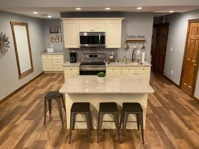 a kitchen with a island with stools and a counter top at STUNNING RENOVATED 4BR House in Southington