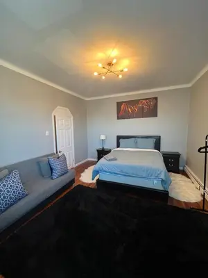 a bedroom with a bed and a couch at Waterfront 4BR apt - 15Min to MetLife and TIMES SQ in Union City