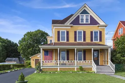 a yellow house with an american flag on the porch at The Grandview, Catskill NY in Catskill