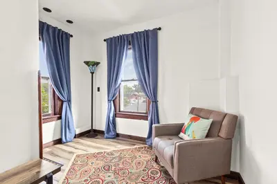 a living room with blue curtains and a chair at The Grandview, Catskill NY in Catskill