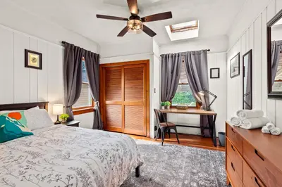 a bedroom with a bed with a ceiling fan and a desk at The Grandview, Catskill NY in Catskill