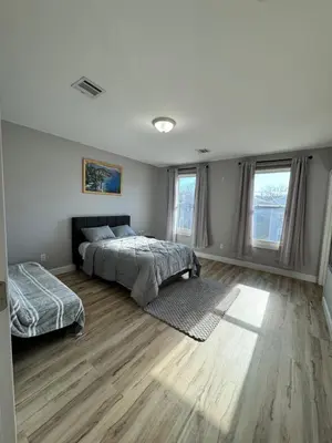 a bedroom with two beds and two windows at Luxury Modern Apt near NYC for 4 people in Jersey City