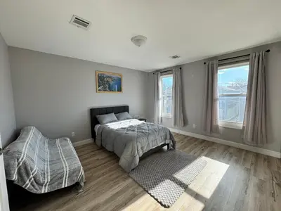 a bedroom with a bed and two windows and a floor at Luxury Modern Apt near NYC for 4 people in Jersey City