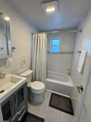 a bathroom with a toilet and a tub and a sink at Luxury Modern Apt near NYC for 4 people in Jersey City